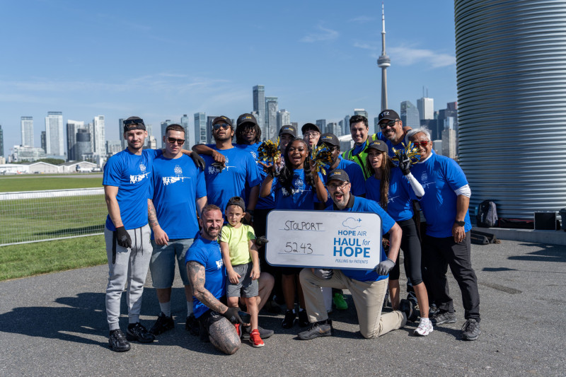 A group smiling for the camera with the city of Toronto in the background