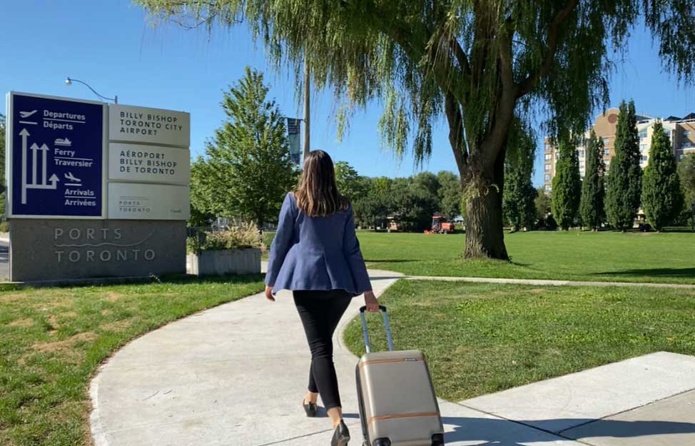 Lady wheeling baggage towards airport