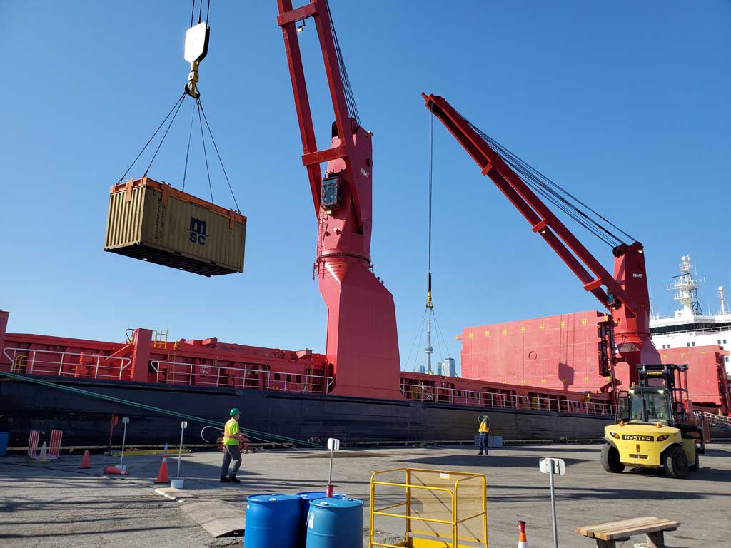 Cargo ship with crane lifting a shipping container