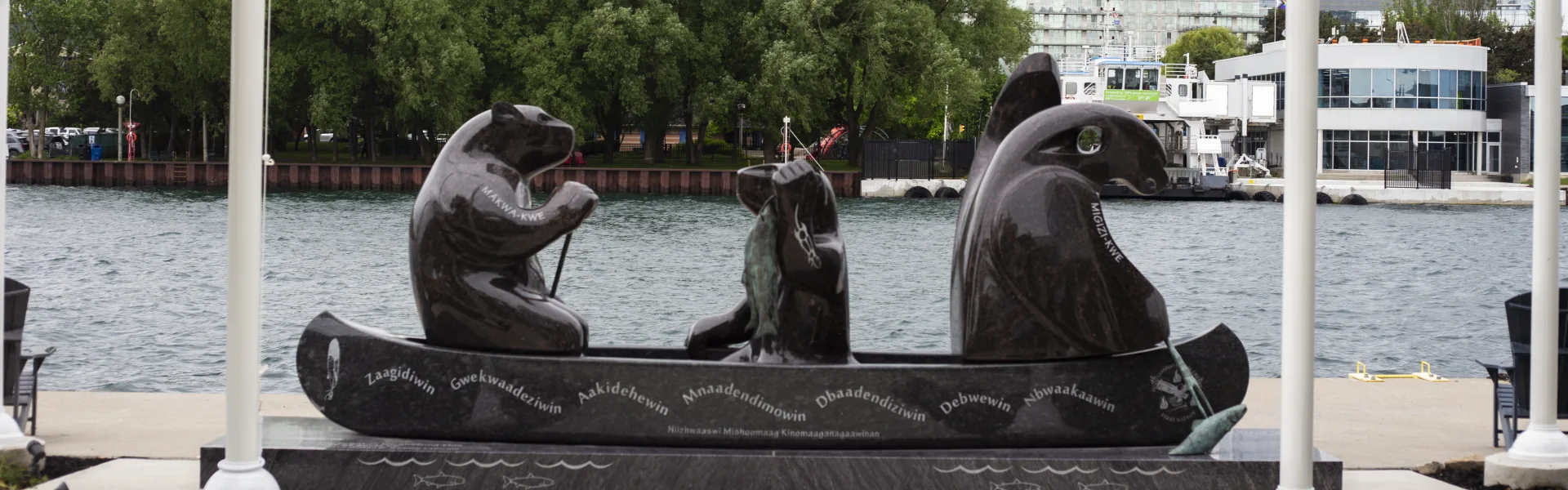A granite sculpture of a canoe carrying bear, human and eagle figures on Toronto’s waterfront, inscribed with the Seven Grandfather Teachings.